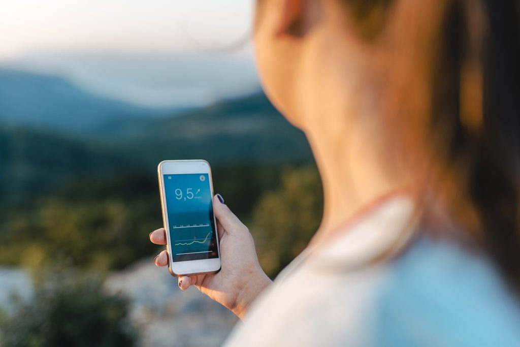 A woman checking her glucose reading on her phone